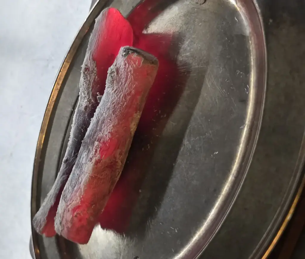 פחם בינצ'וטאן יפני מוכן לשימוש, אדום בוהק על מגש מתכת